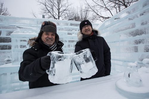 Paul Kostas and Andy Zhao clink ice mugs in the outdoor bar at the Great Ice Show at The Forks Sunday before the area opens to the public on Monday. Workers were "testing" some of the slides before taking a lunch break. 160124 - Sunday, January 24, 2016 -  MIKE DEAL / WINNIPEG FREE PRESS