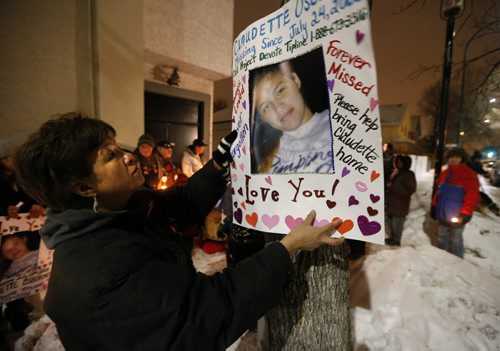 January 24, 2016 - 160124  -  Brenda Osbourne (R), mother of missing woman Claudette Osborne, hangs a poster of her daughter as family and friends joined her for a vigil Sunday, January 24, 2016. Family and friends gathered on Selkirk at King St the last possible location Claudette Osborne was seen July 2008. John Woods / Winnipeg Free Press