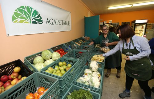 Ada Aburto (left) and Sinae Choi stock vegetables at Agape Table's low-cost grocery at 175 Colony St., near Broadway and Osborne Street on Jan. 27, 2016. Agape Table offers choices of good nutritious food for at-cost (or below) prices, so community members can have the opportunity to eat healthy. The Community Nutrition Centre offers a variety of emergency and low-cost meal and grocery programs to assist low-income residents of Winnipeg. Photo by Jason Halstead/Winnipeg Free Press RE: Social Page