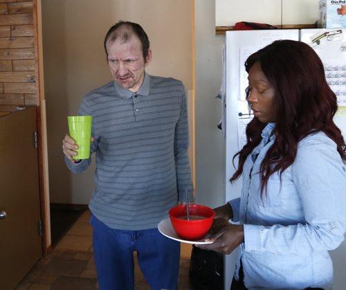 Jemimah Seidu, a Residential Treatment Worker with soup and sandwich for Bert Gockel at left.She works in the New Directions home in the RM of Springfield where 3 intellectually disabled men live. Carol Sanders story Wayne Glowacki / Winnipeg Free Press Jan. 28 2016