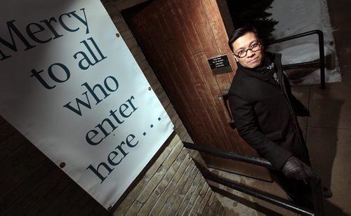 Rev. Geoffrey Angeles poses at the "Holy Door of Mery"  at St. Mary's Cathedral's Carlton Street side.  As part of a worldwide initiative by Pope Francis, Catholics are putting up signs and designating doors as "Holy Doors of Mercy" in different cathedrals saying.....  "mercy to all who enter here." See Brenda Suderman story. January 29, 2016 - (Phil Hossack / Winnipeg Free Press)