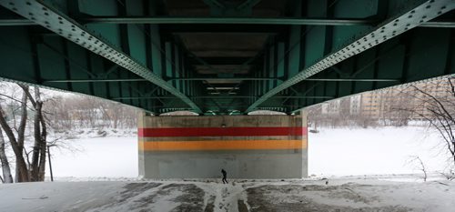 A jogger makes their way along the river trail underneath the Donald Street Bridge a brief respite to the blowing snow and blizzard like conditions Sunday morning.  160207 February 7, 2016 Mike Deal / Winnipeg Free Press