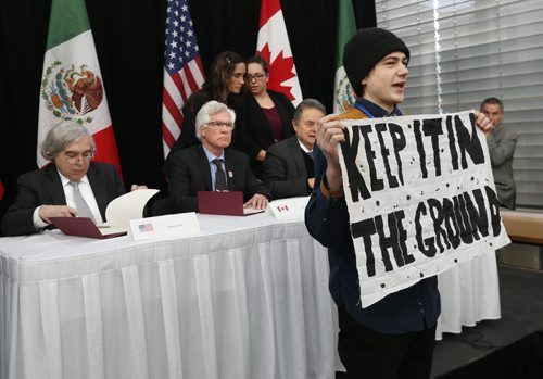 A protestor stepped in front of the cameras as Jim Carr, Minister of Natural Resources, centre , Mexicos Secretary of Energy, Pedro Joaquín Coldwell at right, and Dr. Ernest Moniz, the United States Secretary of Energy in Winnipeg sign a collaborative agreement at their North American Energy Ministers Meeting in Winnipeg.   Kristin Annable story Wayne Glowacki / Winnipeg Free Press Feb. 12 2016