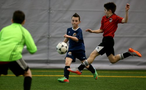 In Under 11 Developmental soccer at the Golden Boy Indoor Soccer Tournament, a player from Bonivital's Jax Chammartin passes the ball before South End United's Claudio Franz can get his foot in the way during their game at the University of Winnipeg, Saturday, February 13, 2016. (TREVOR HAGAN/WINNIPEG FREE PRESS)