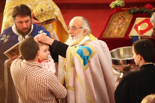 Faith Page. The Patriarch Irinej of the Serbian Orthodox Church from Belgrade performs baptisms at St. Slava Serbian Orthodox at 580 Talbot Ave Saturday. The two babies being baptized were Sara Djelmo, held by her father, Milenko (checkered) and Pavle Miludinovic  the infant son of  Rev. Sinisa Miludinovic (in black on right).  See Brenda Suderman's story,  February 13, 2016 Ruth Bonneville / Winnipeg Free Press