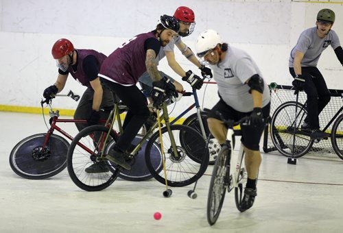A team called 3M in the grey shirts, versus the Eyebrows in the purple jerseys, during a bike polo tournament at the Duncan Sportsplex, Sunday, February 14, 2016. (TREVOR HAGAN/WINNIPEG FREE PRESS)