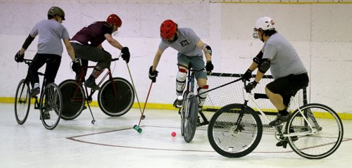 A team called 3M in the grey shirts, versus the Eyebrows in the purple jerseys, during a bike polo tournament at the Duncan Sportsplex, Sunday, February 14, 2016. (TREVOR HAGAN/WINNIPEG FREE PRESS)