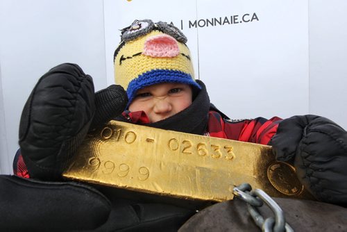 Mike Deal / Winnipeg Free Press Grayson Drzystek, 3, from Selkirk, MB, tries to lift a 400 oz gold bar that was on display by the Royal Canadian Mint at the Festival du Voyageur. The 99.99% pure gold bar is currently worth over $480,000 US and was chained to the display guarded by several police officers.  160215 February 7, 2016