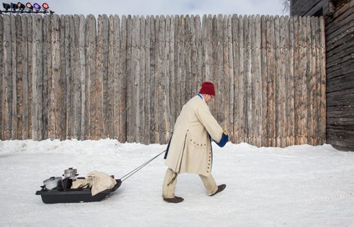 Mike Deal / Winnipeg Free Press A volunteer dressed in period costume walks past Fort Gibraltar at the Festival du Voyageur on Louis Riel Day. 160215 - Monday, February 15, 2016