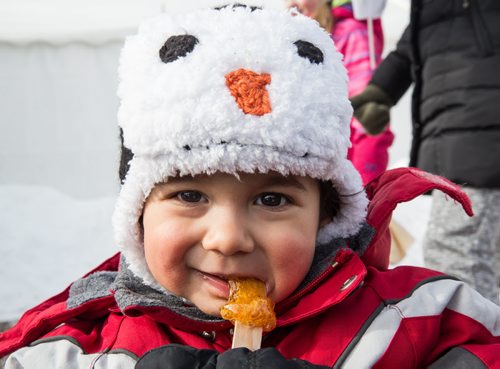 Mike Deal / Winnipeg Free Press Luc Pambrun, 16 months, enjoys a maple taffy pop from the Sugar Shack at the Festival du Voyageur on Louis Riel Day. 160215 - Monday, February 15, 2016