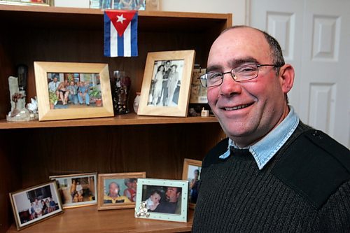 BORIS MINKEVICH / WINNIPEG FREE PRESS  080219 Ramon Raneano Rodriguez poses for a photo in front of some family photos and a cuban flag at his home. For story of Castro's resignation.