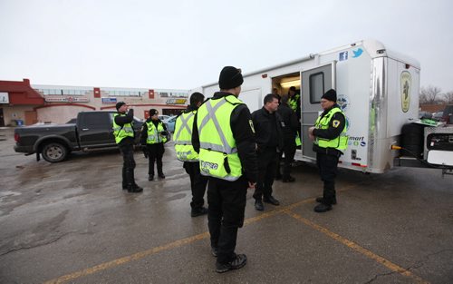 Ruth Bonneville / Winnipeg Free Press Members of the Winnipeg Police Ground Search and Rescue and volunteers prepare to leave for the day a dispatch trailer set up in the parking lot of McIvor Mall after searching along the banks of the Red River north of the Perimeter off Henderson Hwy. Thursday.    Feb 18, 2016