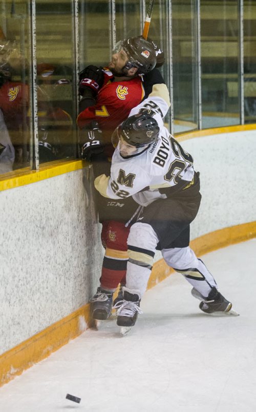 DAVID LIPNOWSKI / WINNIPEG FREE PRESS  University of Manitoba Bisons Jordan Boyd (#22) crashes into University of Calgary Dinos Max Ross #7 Friday February 19, 2016 at Wayne Fleming Arena at Max Bell Centre. This is the first game in the Canada West Quarter Final best-of-three playoff series.
