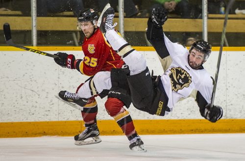 DAVID LIPNOWSKI / WINNIPEG FREE PRESS  University of Manitoba Bisons Liam Bilton (#8) hits the ice as University of Calgary Dinos Kevin King #25 tries to avoid a skate to his face Friday February 19, 2016 at Wayne Fleming Arena at Max Bell Centre. This is the first game in the Canada West Quarter Final best-of-three playoff series.