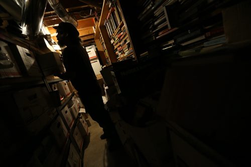 TREVOR HAGAN / WINNIPEG FREE PRESS Bill Fugler owns the Neighbourhood Book Store & Café, Saturday, February 20, 2016. Shown here in the basement looking through thousands of books in boxes. For THIS CITY - Dave Sanderson
