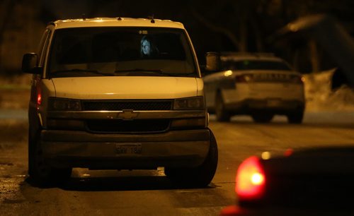 TREVOR HAGAN / WINNIPEG FREE PRESS A Winnipeg Police Forensic Investigator, lit by her laptop screen, at a large crime scene on Bayne Crescent in the early morning hours of Sunday, February 21, 2016.