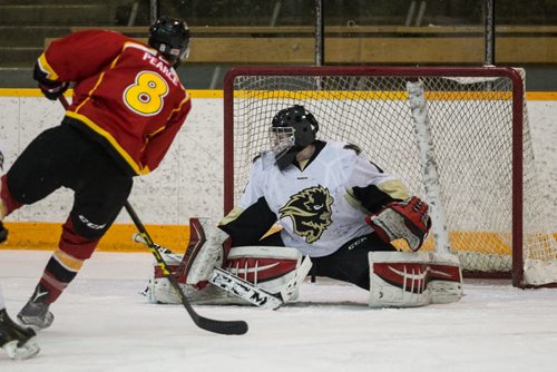 MIKE DEAL / WINNIPEG FREE PRESS University of Calgary Dinos Elgin Pearce (8) scores another goal against University of Manitoba Bisons goaltender Justin Paulic (1) in the third game of the Canada West quarter final best-of-three playoff series at Max Bell Arena. 160221 - Sunday, February 21, 2016