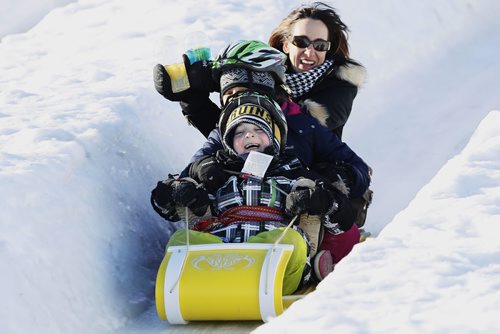 JOHN WOODS / WINNIPEG FREE PRESS Matteo, Victoria and mother Keverley Malawski (front to back) slide down a hill on the last day of the Festival du Voyageur Sunday , February 21, 2016.