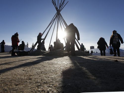 JOHN WOODS / WINNIPEG FREE PRESS Families enjoy a fire as the sun sets on the last day of the Festival du Voyageur Sunday , February 21, 2016.