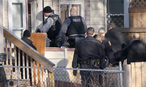 JOE BRYKSA / WINNIPEG FREE PRESS  Winnipeg Police Tactical officers storm a residence at 570 Spence St Thursday near 920 Am- Several individuals were led out of the home by police in handcuffs from the scene, February 25, 2016.( Breaking News)