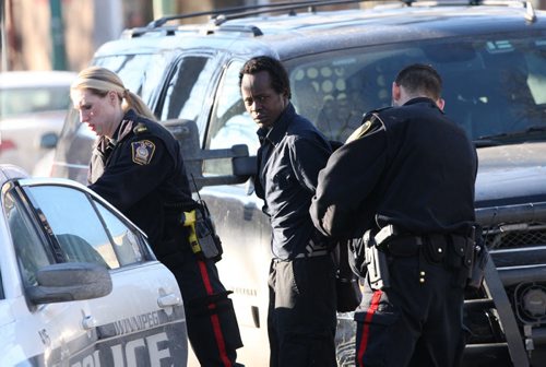 JOE BRYKSA / WINNIPEG FREE PRESS   Winnipeg Police take a person in custody  from a residence at 570 Spence St Thursday near 920 Am- Several individuals were led out of the home by police in handcuffs from the scene- ambulance standing by, February 25, 2016.( Breaking News)