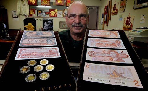 BORIS MINKEVICH / WINNIPEG FREE PRESS Collectibles Canada Coin and Currency Store's Sheldon Sturrey with $2 display. Royal Canadian Mint announced toonie is celebrating 20th anniversary. Sheldon Sturrey has some old $2 bank notes from the 50s and 30s. He helps show the evolution from bill to coin over the years. Reporter: Alexandra De Pape. Photo taken February 25, 2016
