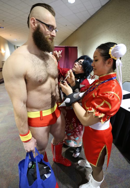 JASON HALSTEAD / WINNIPEG FREE PRESS  May-Fong Yee, dressed as Chun-Li from Street Fighter (right), and Chandra Fontaine, dressed as Koujaku from 'Dramatical Murder,' help apply makeup to Nick Enns, dressed as Zangief from Street Fighter, at the fifth annual Ai-Kon Winter Festival at the RBC Convention Centre on Feb. 27, 2016. The event, which focuses on anime, featured exhibitors and vendors, artist's alley, as well as a gamers' lounge, Mario Kart 8 and Super Smash Bros 4 tournaments and dance.