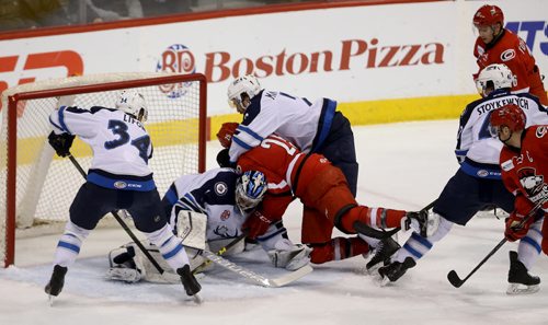 TREVOR HAGAN / WINNIPEG FREE PRESS Manitoba Moose goaltender Eric Comrie (1) makes a pad save as Andrew MacWilliam brings down Charlotte Checkers' Ethan Werek (25) during first period AHL hockey action at MTS Centre, Saturday, February 27, 2016.