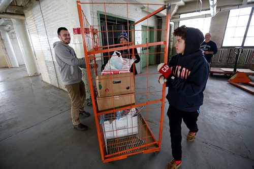 TREVOR HAGAN / WINNIPEG FREE PRESS  From left, Benji Aziza a Jewish student from the University of Manitoba, and Jalal Naso and his brother, Farhad Naso, members of the Yazidi community, sorting donations for Yazidi refugees at a warehouse on Higgins Avenue, Sunday, February 28, 2016. for Carol Sanders story