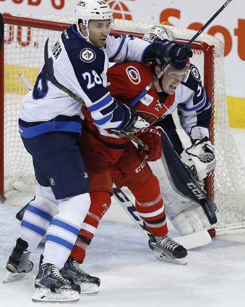 JOHN WOODS / WINNIPEG FREE PRESS Manitoba Moose Patrice Cormier (28) handles Charlotte Checkers' Patrick Brown (24) in front of his goaltender Connor Hellebuyck (37) during first period AHL action in Winnipeg on Sunday, February 28, 2016.