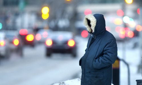 WAYNE GLOWACKI / WINNIPEG FREE PRESS Minimize any exposed skin out there Monday morning as the temperature dropped to -23C . A pedestrian braves the wind  crossing  Portage Ave. at Carlton Street. February 29 2016.