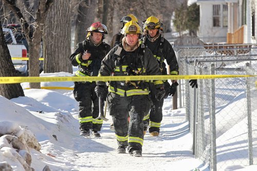 MIKE DEAL / WINNIPEG FREE PRESS Firefighters in front of a fire at a house in the 500 block of Beverly Street at Sargent Avenue, two people were being examined by emergency paramedics at the scene for possible smoke inhalation. The fire damaged the house as well as destroyed the garage.   160302 March 02, 2016