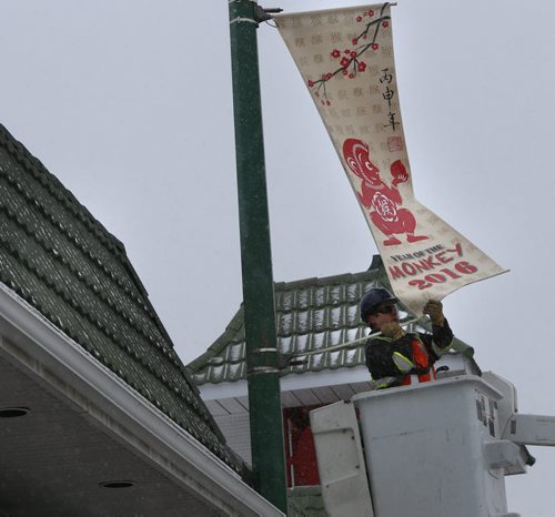WAYNE GLOWACKI / WINNIPEG FREE PRESS    
Dustin Kipling with Mytec Industries Ltd. installs a new 2016 Year of the Monkey Banner on King St. in Chinatown Friday morning.  This banner replaces the 2015 Year of the Sheep banner. The Winnipeg Chinese Cultural and Community Centre along with the Downtown Winnipeg BIZ have been displaying banners since 1991 as a way to celebrate the downtown culture. see release March 4 2016