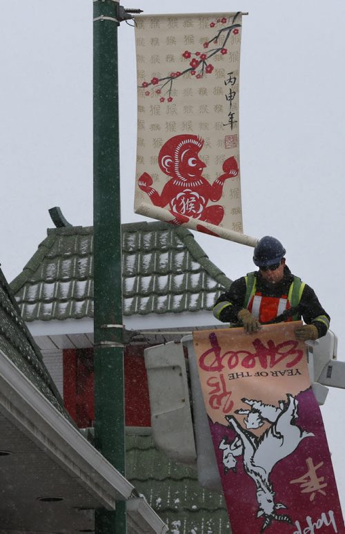WAYNE GLOWACKI / WINNIPEG FREE PRESS   
 Dustin Kipling with Mytec Industries Ltd. rolls up the old  2015 Year of the Sheep banner as he  installs the new 2016 Year of the Monkey Banner on King St. in Chinatown Friday morning.   The Winnipeg Chinese Cultural and Community Centre along with the Downtown Winnipeg BIZ have been displaying banners since 1991 as a way to celebrate the downtown culture. see release March 4 2016