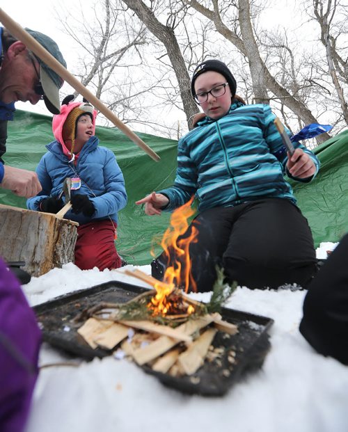 JASON HALSTEAD / WINNIPEG FREE PRESS  Alexina Nault, 12, of the 31st Pathfinders gets the team's fire started as more than 300 Scouts tested their survival skills in Scouts Canadas annual Klondike Derby on March 5, 2016, at Camp Amisk south of Winnipeg. Teams of six to eight Cub Scouts, Scouts, Girl Guides and Pathfinders pulled a Klondike-style sleigh over a 2.5-kilometre course through the woods, competing at tasks including fire lighting, a flood disaster scenario and a simulated ice rescue.