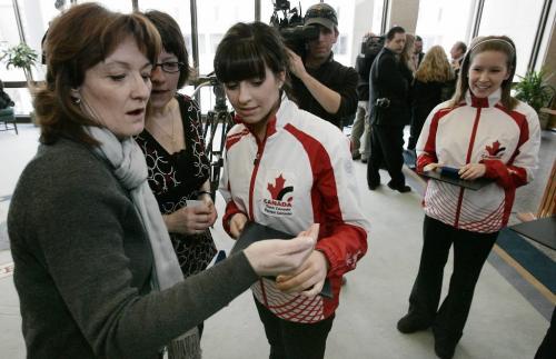 John Woods / Winnipeg Free Press / February 25, 2008 - 080225 - Liz Peters' mother Bev (L - other woman is unidentified) )looks at her medal, as Kaitlyn Lawes looks on, after a ceremony recognizing their achievement.  Mayor Sam Katz presented a medal to the junior curling team of Kaitlyn Lawes at city hall Tuesday February 26, 2008.  The team (L to R) is made up of Kaitlyn Lawes, Jenna Loder, Liz Peters, Sarah Wazney, and MJ McKenzie.