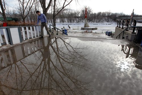 BORIS MINKEVICH / WINNIPEG FREE PRESS Skating at the Forks or the river trail is all but a memory as warm weather forced the trail to be closed. Workers have been removing all the benches and warm up huts. Here an unidentified man negotiates around a puddle there. Photo taken March 07, 2016