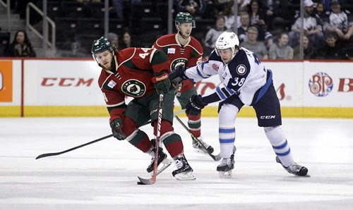 PHIL HOSSACK / WINNIPEG FREE PRESS Iowa Wild #44 Christoph Bertschy takes the puck past  Manitoba Moose #38 Darik Angeli and heads towards the Moose end at the MTS Center Wednesday. March 9, 2016