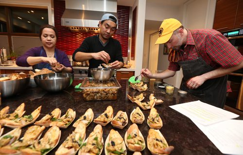 JASON HALSTEAD / WINNIPEG FREE PRESS  L-R: NorWest cooking and food skill programmer Abby Legaspi, Ryan Lao (NorWest 'volunteer extraordinaire') and NorWest community chef Grant Mitchell put together food servings at NorWest Co-op Community Food Centre's Sip & Savour fundraiser on Feb. 24, 2016.(See Social Page)