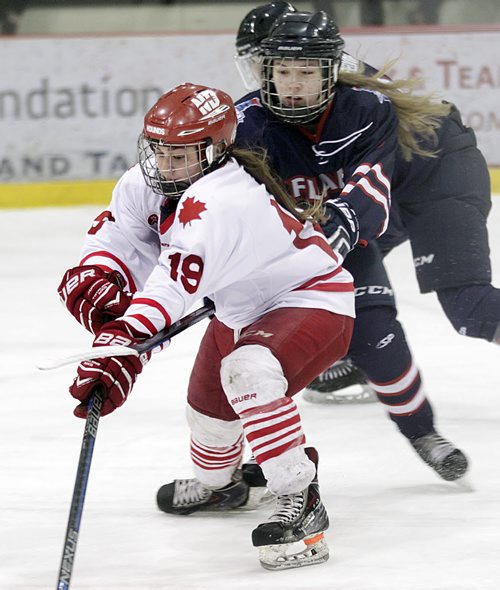 PHIL HOSSACK / WINNIPEG FREE PRESS St. Mary's Academy Flame #5 Hailey Cloutier puts a hook across the wrist of Notre Dame Hound #19 Robin Nimigeers Thursday evening at the Ice Plex during World Sport School Challenge. See Tim Campbell story.  March 10, 2016