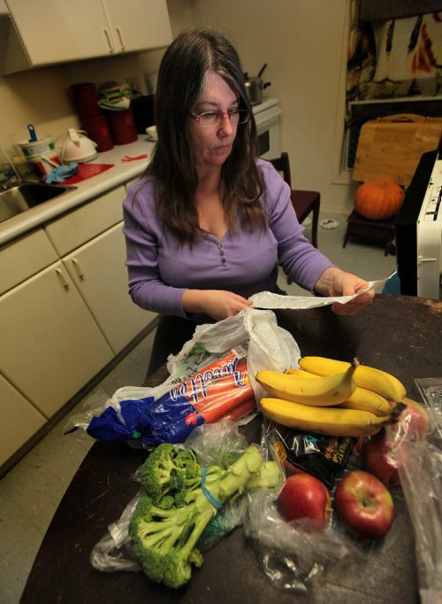 PHIL HOSSACK / WINNIPEG FREE PRESS Joy Black, a mother of two on assistance poses in her kitchen with a few fruits and vegetables and her grocery bill. See Joel Schlesinger story.   March 10, 2016