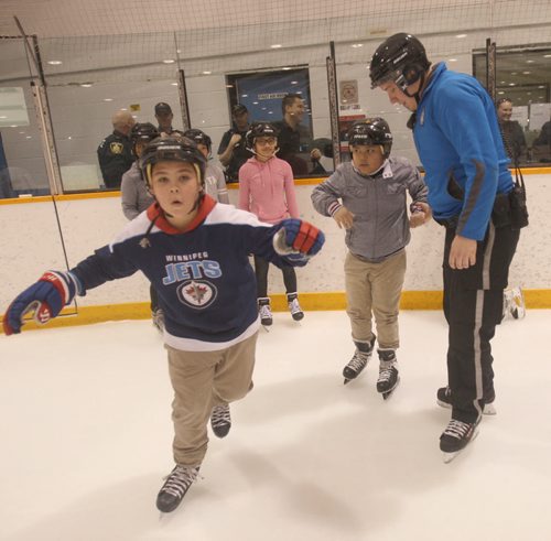 JOE BRYKSA / WINNIPEG FREE PRESS  About 120 kids joined the Winnipeg Police, Cadets at Pioneer Arena (799 Logan Avenue) for a afternoon skate called Skates and Badges -  The learn-to-skate event  brought about 120 children who enjoyed drinks and pizza after the event-  Winnipeg police Service  Cadet Sean Olinkis, with kids from Wellington Elementary School- March 11, 2016.(Standup Photo)