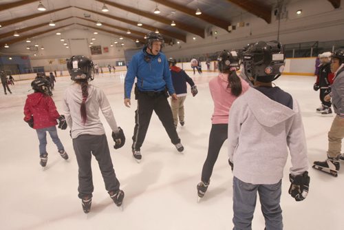 JOE BRYKSA / WINNIPEG FREE PRESS  About 120 kids joined the Winnipeg Police, Cadets at Pioneer Arena (799 Logan Avenue) for a afternoon skate called Skates and Badges -  The learn-to-skate event  brought about 120 children who enjoyed drinks and pizza after the event-  Winnipeg police Service  Cadet Sean Olinkis, with kids from Wellington Elementary School- March 11, 2016.(Standup Photo)
