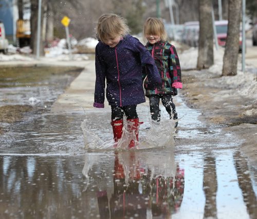 RUTH BONNEVILLE / WINNIPEG FREE PRESS  Summer McGraw (4yrs) and her little sister Georgia (3yrs) play in puddles while walking with their mom near Deer Lodge Saturday.  Standup March 12, 2016