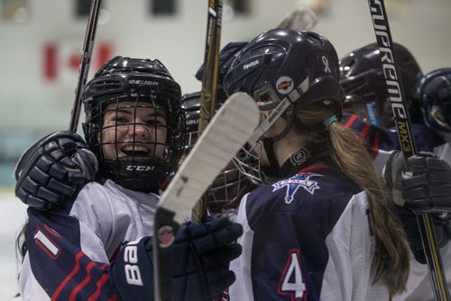 MIKE DEAL / WINNIPEG FREE PRESS St. Mary's Academy Flames' Holly Reuther (10) (left) celebrates after scoring her second goal against the Balmoral Hall Blazers in the bronze medal game of the 2016 Female World Sport School Challenge at the MTS IcePlex on Sunday. 160313 - Sunday, March 13, 2016