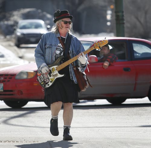 WAYNE GLOWACKI / WINNIPEG FREE PRESS  Local musician Patrick Boggs heads along Main Street during his walk through the city Monday afternoon enjoying the beautiful spring weather and rehearsing for an up coming blue grass show.  March 13 2016