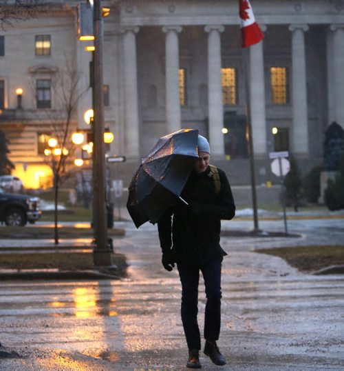 WAYNE GLOWACKI / WINNIPEG FREE PRESS  Umbrellas are out Tuesday morning as rain showers are in the forecast through out the day.  Pedestrian at cross walk on Broadway. March 15 2016