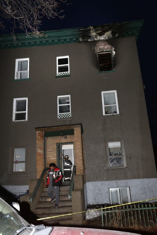 WAYNE GLOWACKI / WINNIPEG FREE PRESS    A man leaves a three storey walk up apartment building in the 600 block of McGee St. Wednesday morning with some items gathered from an apartment after an early morning fire. March 16 2016