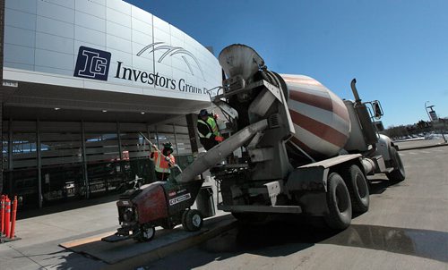 PHIL HOSSACK / WINNIPEG FREE PRESS Workers unload small batches of concrete to be trucked up to upper levels at the Investors Group Field stadium Friday. See story. MARCH 18, 2016