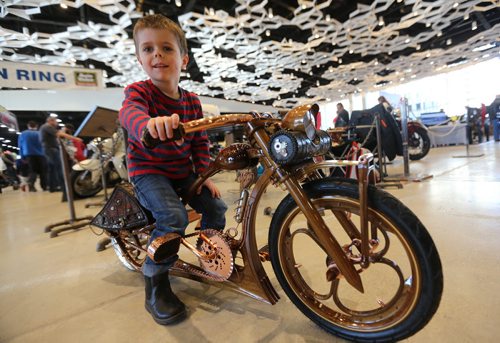 TREVOR HAGAN / WINNIPEG FREE PRESS At the World of Wheels car show at the Winnipeg Convention Centre, Nathan Kovacs, 5, sitting on the custom bike that his father Krisztian, built from scratch using black walnut wood and metal parts, Friday, March 18, 2016.